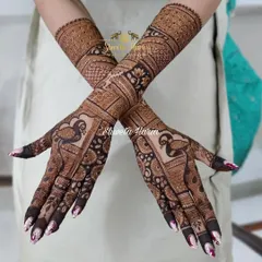 A crossed-arm view of the bridesmaid's mehendi, highlighting the flow and complexity of the traditional peacock patterns.