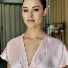 This is an unedited, behind-the-scenes portrait from a diamond jewellery shoot. The makeup is clean and luminous, focusing on perfected skin, a soft wash of color on the eyes, and a natural lip. The sleek, pulled-back hair adds to the sophisticated and modern aesthetic.