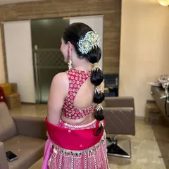 A modern and chic bubble braid, adorned with a stunning traditional hair accessory. This style is perfect for a Sangeet or Mehendi.