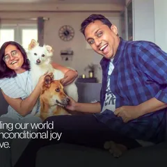 A moment of pure, chaotic joy with a couple and their two dogs. This photo perfectly captures the fun and energy of a multi-pet household.