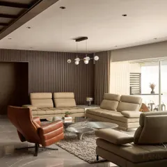 Welcome to Project Acropolis. The living room is designed for formal entertaining, featuring plush leather sofas, a sculptural coffee table, and a warm, layered lighting scheme to create an inviting ambiance.