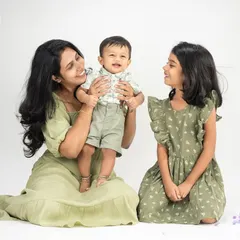 A lovely studio portrait of a mother with her two children. The coordinated outfits and gentle interaction highlight the sweet bond between siblings and their mom.