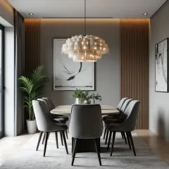 We used a layered fringe chandelier to add texture and a unique design element to this intimate dining space. The back wall features wood paneling that adds warmth, contrasting with the cool grey tones of the chairs and rug.