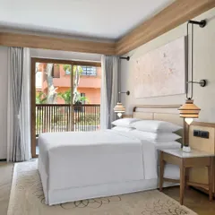 The interior of our suites features a king-sized bed with premium linens, elegant artwork, and soft, ambient lighting, creating a restful atmosphere for a perfect night's sleep.