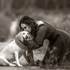 A deeply emotional black and white portrait of a woman sharing a tender kiss with her dog. This image captures the profound, unconditional love between a human and her pet.