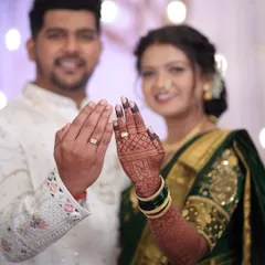 A happy couple showing their engagement rings. The bride's rich mehendi stain is a beautiful backdrop for this special moment.