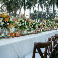 A beautiful long-table dinner setup for a rustic-boho sangeet in Goa. The table is lined with pampas grass and wildflowers, perfectly complementing the natural, beachy surroundings.