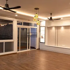 This living room opens up to a balcony with large glass doors, flooding the space with natural light. The clean lines of the TV unit and furniture contribute to the bright and airy feel.