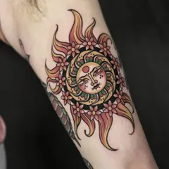 This traditional-inspired sun tattoo glows with warmth and meaning. The use of bold outlines and a classic color palette of reds, yellows, and greens gives this piece a timeless, ornamental quality.