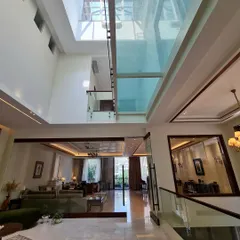 This home is defined by its clean geometry and open spaces. A massive skylight floods the double-height entryway with light, creating a sense of volume and connecting the different levels of the home.