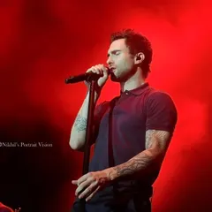 A close-up of Adam Levine singing under intense red lighting. This shot focuses on the emotion and passion of the performance, a key element I always look for in my concert photography.