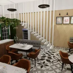 A different angle of the cafe visualization, highlighting the staircase and seating arrangement. The white slatted partition for the stairs keeps the space feeling open and bright, while the mix of booth and chair seating offers flexibility.