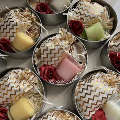 A peek inside the return favour tins, revealing small scented candles and treats packed in a decorative potli bag.