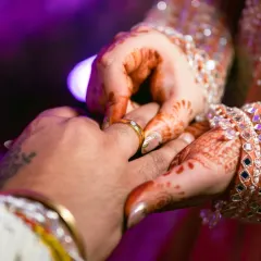 A close up of the ring exchange, a key moment of any engagement. The focus is on their hands and the symbol of their commitment.