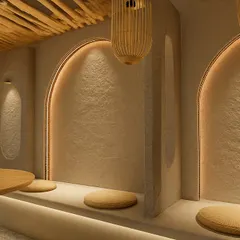 A close-up of the Japanese-inspired low seating nooks at 6th Empirica. The arched alcoves with integrated lighting and textured walls provide intimate spaces within the larger open-plan layout, offering guests a sense of privacy and comfort.