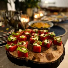 A close-up of our watermelon and feta bites, beautifully arranged on a rustic wooden platter. This refreshing appetizer is a guest favorite, perfect for warm-weather events and sophisticated gatherings.