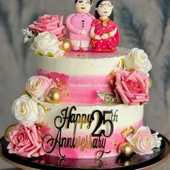 Celebrating 25 years of love with this stunning two-tier anniversary cake. It features a pink ombre design, fresh flowers, and adorable custom fondant toppers of the couple in traditional attire.