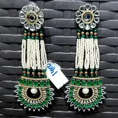 A very grand and long pair of earrings for a truly dramatic look. They feature a kundan top with long strings of pearls and a large green stone design at the bottom, perfect for a bridal ensemble.
