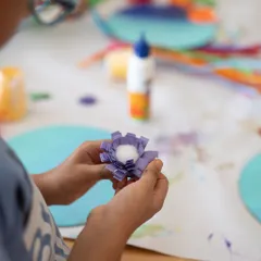 Here, a child is crafting a delicate paper flower. My classes cover a wide range of crafts, not just painting. We explore paper art, sculpture, and mixed media to keep things exciting and help kids discover new passions.