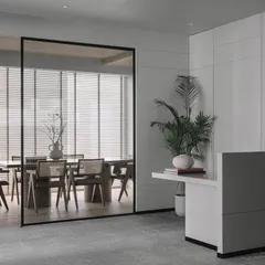 The entrance to this office was designed to be professional yet welcoming. A smoked glass partition offers a glimpse into the meeting room, balancing privacy and openness, while a clean, minimalist reception desk sets a sophisticated tone.