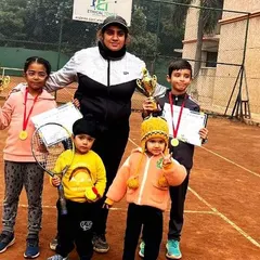 A coach with some of our youngest winners, including toddlers holding their own rackets. This photo from our Saket tournament shows that it is never too early to start learning and celebrating on the court.