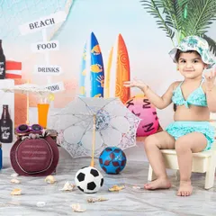 Life's a beach! This little girl is enjoying the sun and sand in my fun beach-themed setup, complete with surfboards and seashells.