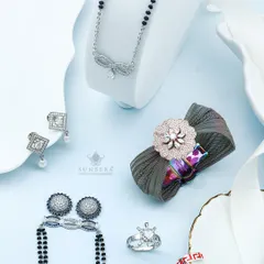 This flat lay showcases the variety in my silver collection. It features a modern mangalsutra with a bow design, square diamond earrings with pearl drops, and a unique fabric scrunchie with a floral diamond centerpiece.