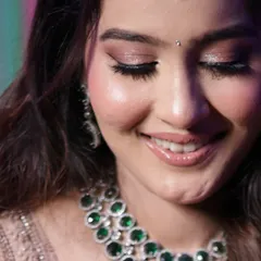 A close-up of the soft, shimmery eye makeup and the bride's joyful smile. The perfect combination for a reception look.