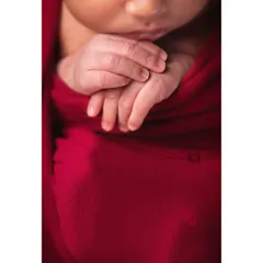 A macro shot of a newborn's tiny hands clasped together, with their little feet visible in the background. These detail shots are a beautiful way to remember how small they were.