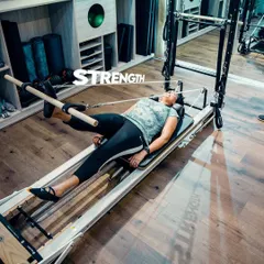 This exercise on the reformer uses the push-through bar to build leg and glute strength. The focus is on slow, controlled movements to maximize muscle engagement.