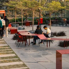The undulating form of the Red Ribbon creates informal zones for dining and socializing. It's a perfect example of how we design "people spaces" that are not just functional but also add a playful, artistic element to the landscape.