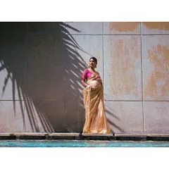 A high-fashion maternity shot. The play of light and shadow, the elegant saree, and the poolside setting combine to create a striking and artistic portrait.