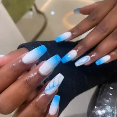 A cool and refreshing blue ombré on long coffin nails. The color fades from a crisp white to a vibrant sky blue, with a marble accent nail for added artistic flair.