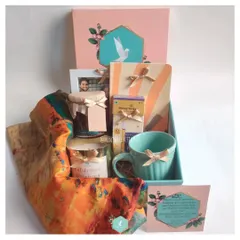 A work anniversary is a special milestone. This colorful hamper was curated to celebrate just that, featuring a personalized frame, a vibrant scarf, a scented candle, a mug, and honey sticks, all packed in our signature pink and teal box.