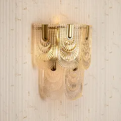 This vintage glam wall light brings an Art Deco feel to any room. The layered, fan-patterned glass creates a beautiful, diffused light effect, making it a stunning decorative piece for a living room or formal entryway.