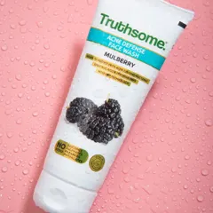 This image for Truthsome's acne defense face wash uses a simple, textured pink background with water droplets to create a clean, clinical, yet appealing look for the skincare product.