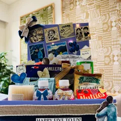 A full view of the 'Five Years of Love' anniversary hamper. The design includes a personalized story board, a scented candle, gourmet snacks, and other thoughtful details, all tied together with a navy blue and jute theme.