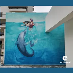 This large-scale outdoor mural in Saan, Gurgaon, creates a stunning visual illusion of a playful dolphin interacting with a swimmer. We love tackling ambitious projects that turn building exteriors into breathtaking works of art.