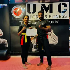 Another dedicated student is awarded her yellow belt and certificate, marking a significant milestone in her kickboxing journey.