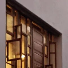 A close look at the window facade of the Kalasangama project. We repurposed old doors and windows from the original site, arranging them into this intricate mosaic. This practice of adaptive reuse is central to my work, allowing us to honor a place's history while creating something entirely new and vibrant.