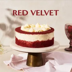 My classic Red Velvet cake, presented on a marble and wood stand. I frost it with a generous amount of rich cream cheese frosting and a border of soft red velvet crumbs.