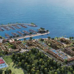A wide aerial shot of a coastal resort, showing the entire property from the tennis courts and residential blocks to the marina and surrounding ocean.