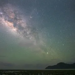 The Milky Way arching over a serene beach in the Andaman Islands. The faint green glow is airglow, a natural phenomenon that adds a magical touch to nightscape photography.