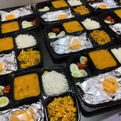 A look at our everyday meal boxes ready for dispatch. Each compartment is filled with a different dish, like dal, a dry sabzi, rice, and a sweet, providing a complete and nutritious meal that tastes just like home.