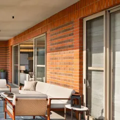 We love blurring the line between indoors and outdoors. This expansive deck at the Max128 apartment uses natural brick and comfortable outdoor furniture to create a true extension of the living space, perfect for enjoying a quiet morning or hosting friends.