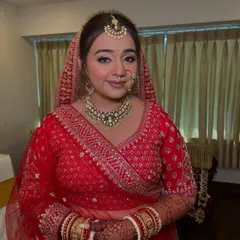 A beautiful front view of a traditional bride. I created a classic bridal updo, providing a clean and elegant frame for her face, maang tikka, and nath.