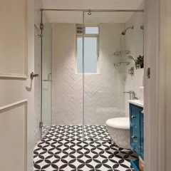 This bathroom renovation shows how I love to play with pattern and color. By contrasting bold, geometric floor tiles with a clean, white herringbone pattern on the walls, I created a high-impact look. The custom teal vanity adds a pop of personality, turning a functional room into a joyful space.
