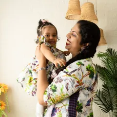 A mother holds her daughter, both sharing a smile. This image was taken during a family session in my studio, which is designed to feel bright, airy, and comfortable.