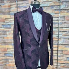 Make a statement in this wine-colored five-piece reception suit. The jacket's textured geometric pattern and shimmer, paired with a matching waistcoat and bow tie, create a polished and celebratory outfit ready for any grand event.