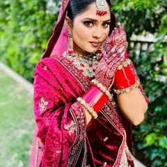 This portrait captures the harmony between the bride's expression and her henna. The detailed mehndi work on her hands and fingers beautifully frames her face.